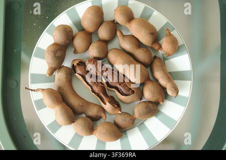 Tamarindenfrüchte, die auf einem Teller in einer Küche angeordnet sind Stockfoto