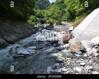 Ein stürzender Bach fließt über glatte Steine Stockfoto