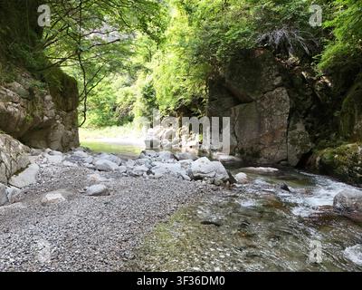 Strömendes Wasser fließt sanft über glatte Steine Stockfoto