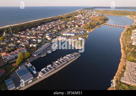 Hochwinkel-Aerial-Panorama, das die Küstenstadt Dziwnow zeigt, die auf einem schmalen Landstreifen gelegen ist, mit dem Fischerhafen und den Docks und Bu Stockfoto
