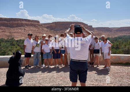 Tafilalet-Palmenhain, Marokko, 30. Mai 2026, Eine große Gruppe von Seniorentouristen in weißen T-Shirts posiert fröhlich, während ein Kollege ihr Foto macht Stockfoto