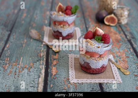 Sammlung von geschichteten Beerendesserts, stilisiert auf einer verwitterten Holzoberfläche mit Vintage-Lebensmittel-Fotografie-Ästhetik Stockfoto