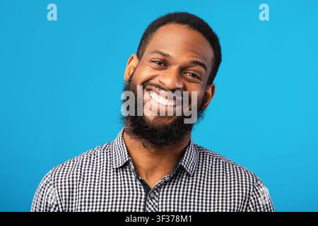 Lächelndes afro Mann Porträt auf blauem Hintergrund Stockfoto