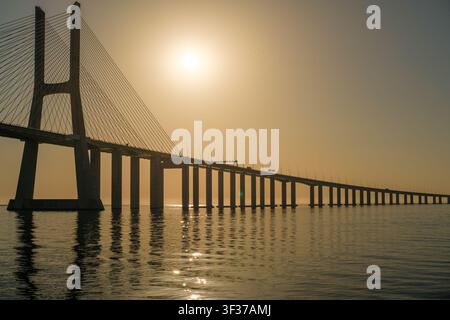 Vasco-da-Gama-Brücke erstreckt sich über den Tejo während eines goldenen Sonnenuntergangs Stockfoto