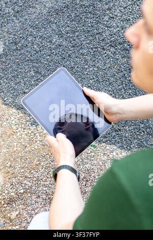 Nahaufnahme eines Mannes, der ein digitales Tablet während einer Inspektion von Bauaggregate-Stapel im Freien verwendet. Konzept der Bauinspektion, digitale Ar Stockfoto