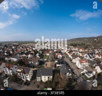 Dieses weitwinklige Panoramafoto, das aus einer erhöhten Perspektive aufgenommen wurde, zeigt eine wunderschöne kleine europäische Stadt unter einem satten blauen Himmel, der mit Stockfoto