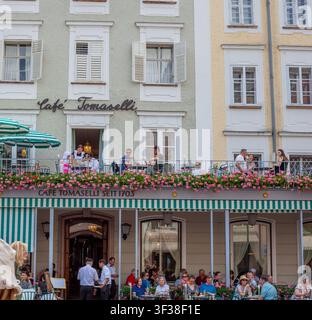 Fassade des berühmten Cafés Tomaselli mit Gästen auf dem Balkon und der Terrasse. Menschen, Touristen in der Altstadtstraße Restaurant Salzburg, Österreich - 22. Juni 2026 Stockfoto