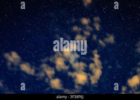 Breitwinkel-Astrofotografie-Aufnahme, die einen sternengesprenkelten Nachthimmel mit einem dichten Feld leuchtender Sterne einfängt, wunderschön unterbrochen von lockeren Wolken Stockfoto