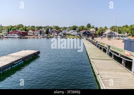 Boote sind am Steg an der Water Street in Baddeck, Nova Scotia, Kanada, vertäut, wobei die Reihe von Häusern in dieser kleinen Hafenstadt am Bras d'Or Lake hinter ihnen sichtbar ist. Baddeck ist ein beliebtes Ziel für Segler und ein Ausgangspunkt für Touren entlang des Cabot Trails auf Cape Breton Island Stockfoto