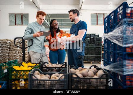 Ein vielseitiges Team, das die Lieferkette für frische Lebensmittel in einem geschäftigen Lager verwaltet Stockfoto