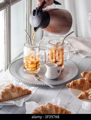 Koffe in ein Glas mit Eis gießen, um Eiskaffee zu machen. Stockfoto