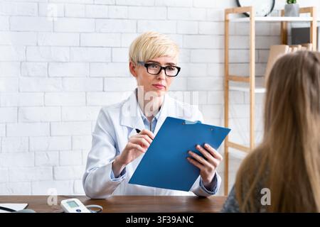Beratung im Büro. Arzt mit Tablet in den Händen hört dem Patienten aufmerksam zu Stockfoto