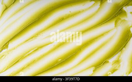 Pistaziencreme-Muster, dubai grüner Schokoladenhintergrund mit Textur, grüner Nusspasta-Hintergrund. Cremige süße Schmiere, Matcha-Eiscreme, Pistazienmousse oder -sauce Stockfoto
