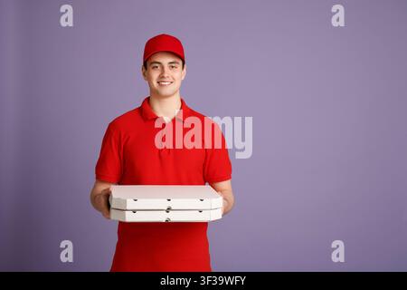 Pizza-Lieferung jederzeit möglich. Lächelnder Kurier rot in Uniform hält Kisten Stockfoto