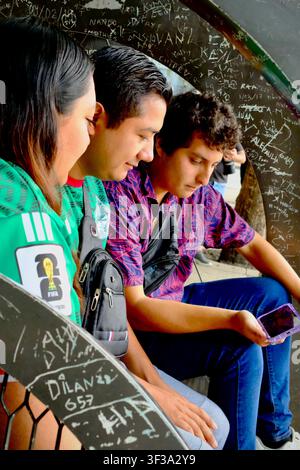 Mexiko-Stadt, CDMX, Mexiko – 19. Juli 2026: Junge Fans beobachten ein Weltmeisterschaftsspiel auf dem Smartphone an der Bushaltestelle Stockfoto