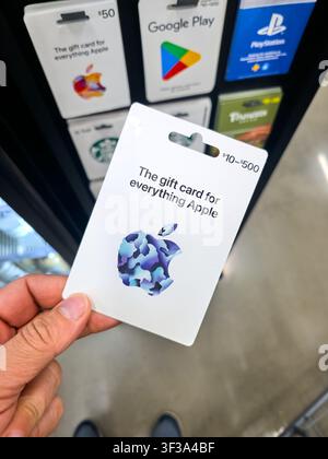 PLANO, TX, 2026 – 12. JULI 2026: Eine Person hält eine Apple-Giftkarte in einem Einzelhandelsgeschäft. Die Karte zeigt ein farbenfrohes Apple-Logo, das ihr us Stockfoto