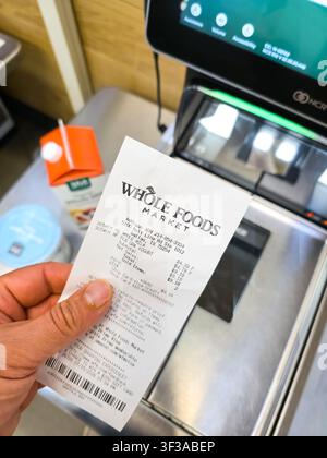 DALLAS - 15. JULI 2026: Ein Kunde hält einen Kassenzettel von Whole Foods Market an einer Selbstbedienungskasse im Inneren des Dallas-Ladens. Whole Foods Market ist bekannt Stockfoto