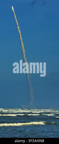 Start der Artemis-II-Rakete, gesehen von New Smyrna Beach, Florida, wie sie über dem Atlantik aufsteigt mit einer dramatischen Rauchspur und einem Horizontwinkel über dem Ozean. Stockfoto