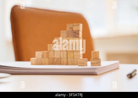Gestapelte Holzblöcke bilden ein Balkendiagramm auf Papier Stockfoto