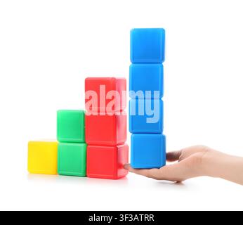 Hand stapelt bunte Plastikblöcke in aufsteigender Reihenfolge Stockfoto