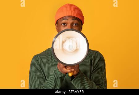 Porträt Des Jungen Schwarzen Hipster Guy Mit Lautsprecher In Den Händen Ankündigung Stockfoto