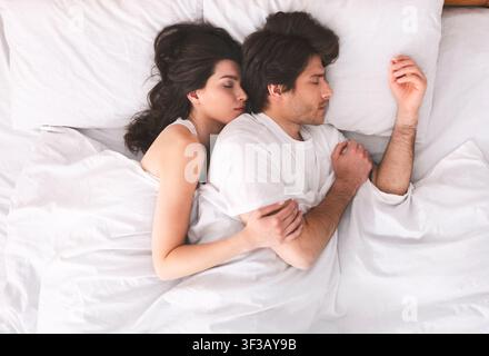 Tausendjährige Ehepaar knuddeln, eng schlafen im Bett Stockfoto