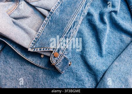 Minimalistische Jeans-Tuch-Banner mit Kontrastnähten und metallischen Knöpfen. Blauer Denim-Jackenärmel und Saumtextur-Hintergrund mit Kopierraum. Stockfoto