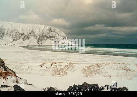 Berlevåg, Norwegen - 31.03.2019: Dramatische Küstenlandschaft mit schneebedeckter Küste und hoch aufragenden schneebedeckten Bergen am Meer Stockfoto