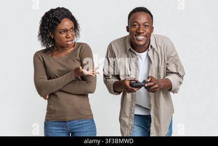Mann spielt Videospiele, Frau ist genervt Stockfoto