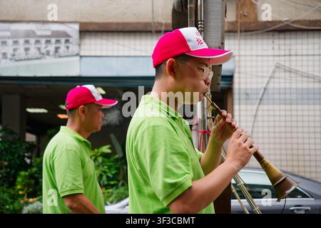 Taipei, Taiwan - 27. Jun 2026: Nahaufnahme eines jungen Suona-Spielers in einer traditionellen Beiguan-Band bei der Xiahai-Stadtgott-Parade in Taipei. Stockfoto