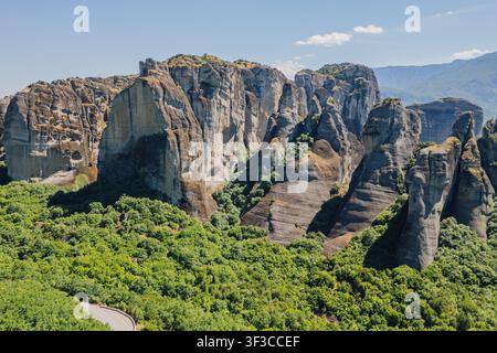 Hochwinkel-Luftaufnahme massiver Felsformationen, die über einer grünen Tal-Waldlandschaft in der berühmten Meteora-Unesco-Weltregion nahe Kalambaka G aufragen Stockfoto