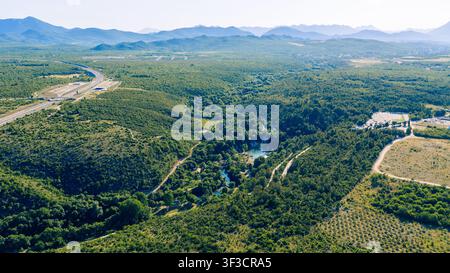 Panoramischer Luftbild-Landschaftsaufnahmen mit grünem Tal, Bergen und einem sich windenden Fluss Stockfoto