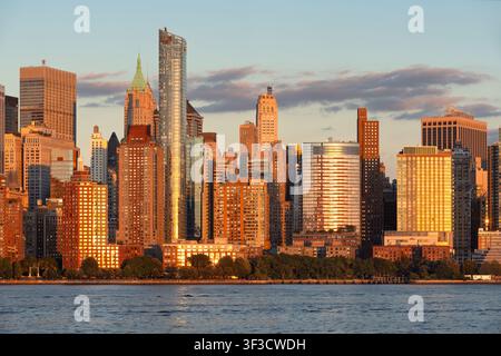 Lower-Manhattan-Skyline mit Wolkenkratzern von Battery Park City bei Sonnenuntergang, gesehen von Jersey City über den Hudson River. New York City Stockfoto