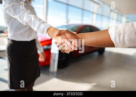 Geschäftsfrauen, die sich nach einem Autohändlerabkommen die Hände schütteln Stockfoto