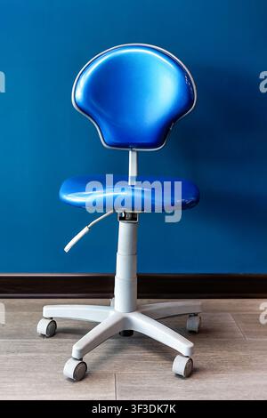 Blauer verstellbarer Zahnarztoperateursstuhl in einer modernen Zahnklinik für Zahnärzte und Dentalhygieniker während der Patientenbehandlung Stockfoto