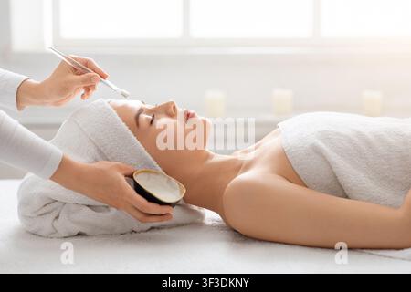 Junge hübsche Frau mit Gesichtsbehandlung im Spa Stockfoto