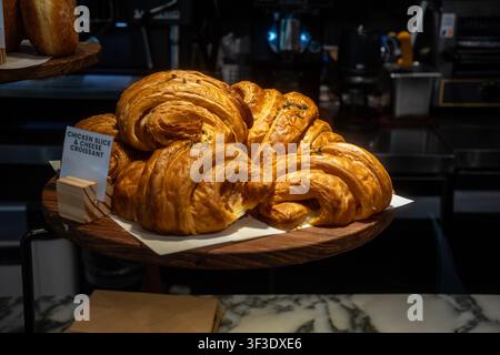 Frisch gebackene Hühnerscheibe und Käse-Croissants auf Holzständer Stockfoto