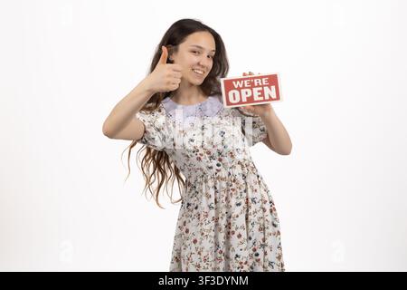 Zufriedene junge Frau hält ein rotes Schild mit fröhlichem Lächeln im Gesicht Stockfoto