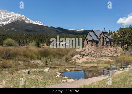 Kapelle auf dem Felsen (Sankta-Katharina-von-Siena-Kapelle), eine historische Steinkirche, steht unterhalb des Mount Meeker in der Nähe eines Teiches in Allenspark, Colorado, USA Stockfoto
