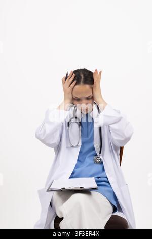 Gestresste junge Frau, die ihren Kopf in Verzweiflung hält und besorgt aussieht Stockfoto