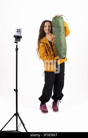 Junge Bloggerin filmt Video-Vlog auf Stativ im Studio Stockfoto