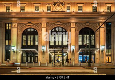 New York, NY - USA - 20. Jul 2026 Die beleuchtete Fassade des Moynihan Train Hall in New York City zeigt großartige klassische Bögen, kunstvolle Steinmetzarbeiten, glo Stockfoto