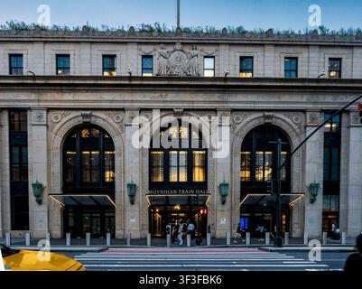 New York, NY - USA - 20. Jul 2026 Symmetrische Fassade des Moynihan Train Hall in New York City in der Dämmerung, mit beleuchteten Bogensch Fenstern und Eingang als p Stockfoto