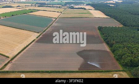 Luftaufnahme von landwirtschaftlichen Feldern mit einem zentralen Drehregensystem, das einen trockenen Bodenbereich bewässert, und betont die Trockenheitsbedingungen im Land Stockfoto
