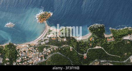 Ein atemberaubendes Luftbild fängt die ikonische Insel Sveti Stefan ein, die durch eine schmale Landenge mit dem Festland in der Nähe von Budva, Montenegro, verbunden ist. Das Bild a Stockfoto