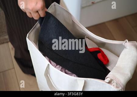 Person, die Kleidung in eine Tasche zu Hause packt Stockfoto
