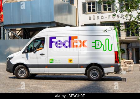 Weißer elektrischer FedEx-Lieferwagen fährt auf einer Kopfsteinpflasterstadtstraße in Zürich, Schweiz - 23. Juni 2026 Stockfoto