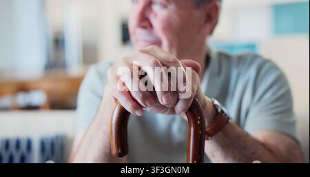 Hände, Gehstock und älterer Mann mit Nachdenken in einer Seniorenresidenz, Achtsamkeits- und Gleichgewichtshilfe mit Nostalgie. Person, Rentner und Gehstock für Stockfoto