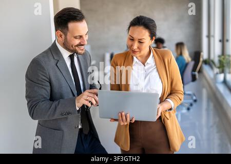 Happymultiethnische Geschäftsleute lachen, während sie an einem neuen Projekt in einem Büro arbeiten. Stockfoto