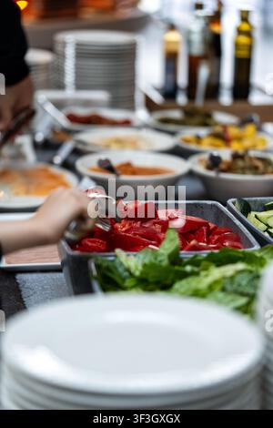 Salatbar-Buffet mit frischen gesunden Gemüsen. Person, die sich frisches gehacktes Gemüse von einer Salatbar in einem Restaurant serviert Stockfoto